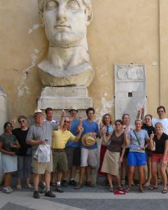 College students in ROme in front of the colossal head of Constantine.