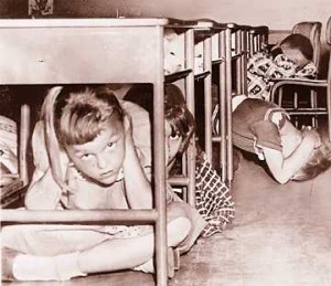 Students demonstrating "Duck and Cover" Circa 1950. Photo Credit: http://undergroundbombshelter.com/news/w…. 