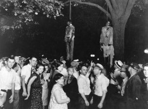 Two African American Men Hang from Trees with a Crowd around them
