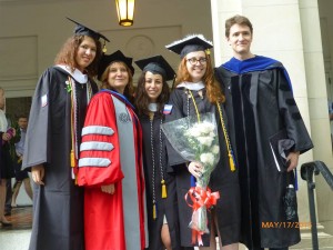 Two graduates from the Russian department join two of their professors for a photo after graduation.