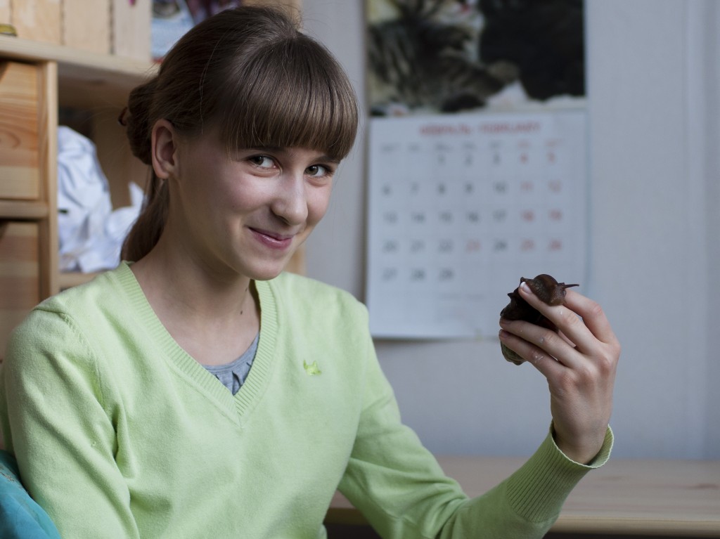 young Russian woman holds pet snail