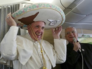 Pope Francis wears a traditional Mexican sombrero hat he received as a gift by a Mexican journalist aboard the plane during the flight from Rome to Habana, Cuba, on his way to a week-long trip to Mexico, Friday, Feb. 12, 2016. The pontiff is scheduled to stop in Cuba for an historical meeting with Russian Orthodox Patriarch Kirill that the Vatican sees as a historic step in the path toward healing the 1,000-year schism that split Christianity. At right is Vatican spokesperson Rev. Federico Lombardi. (Alessandro Di Meo/Pool Photo via AP)