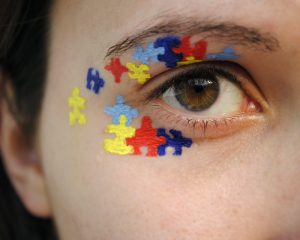 a boy's eye with puzzle pieces painted around it