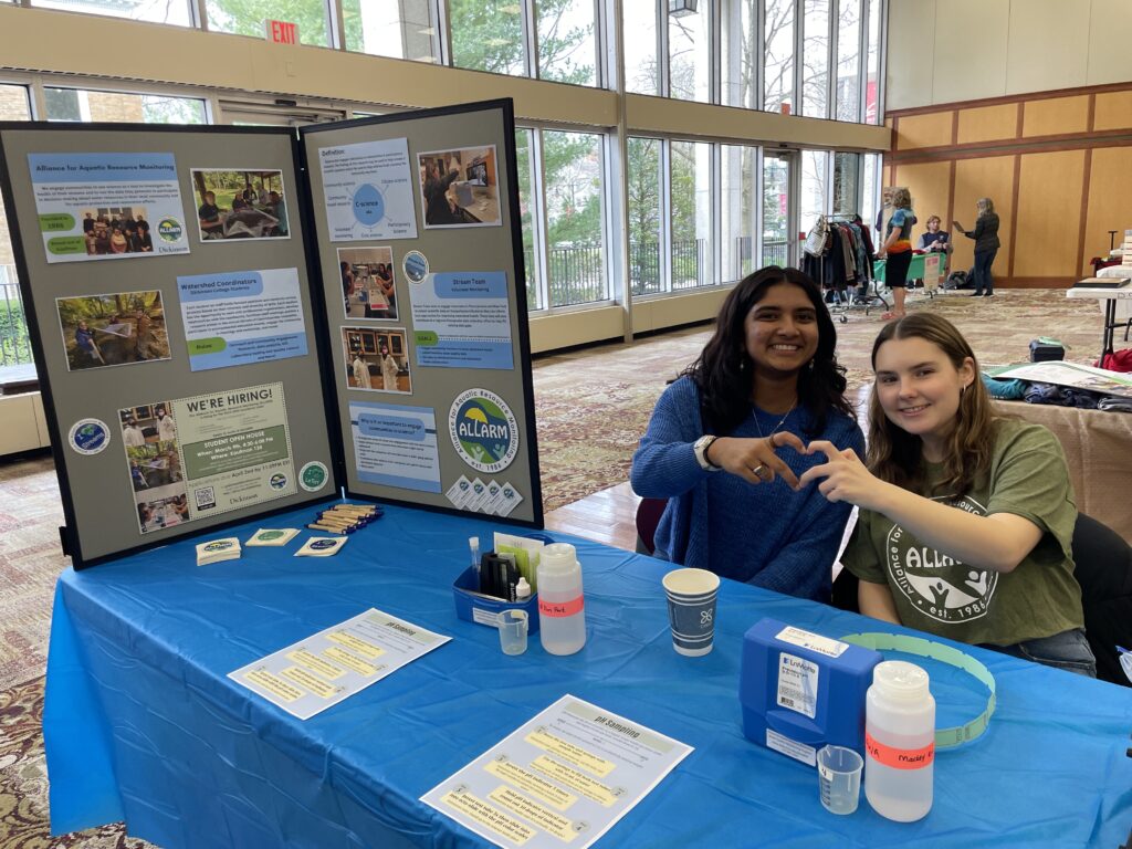 Prerana and Kailey pose behind the Sustainability Expo table
