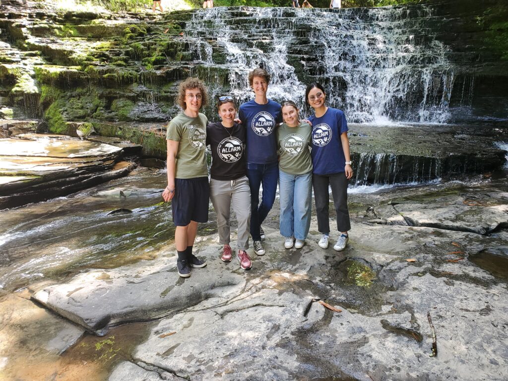 the ALLARM team poses in front of a waterfall at Salt Springs.