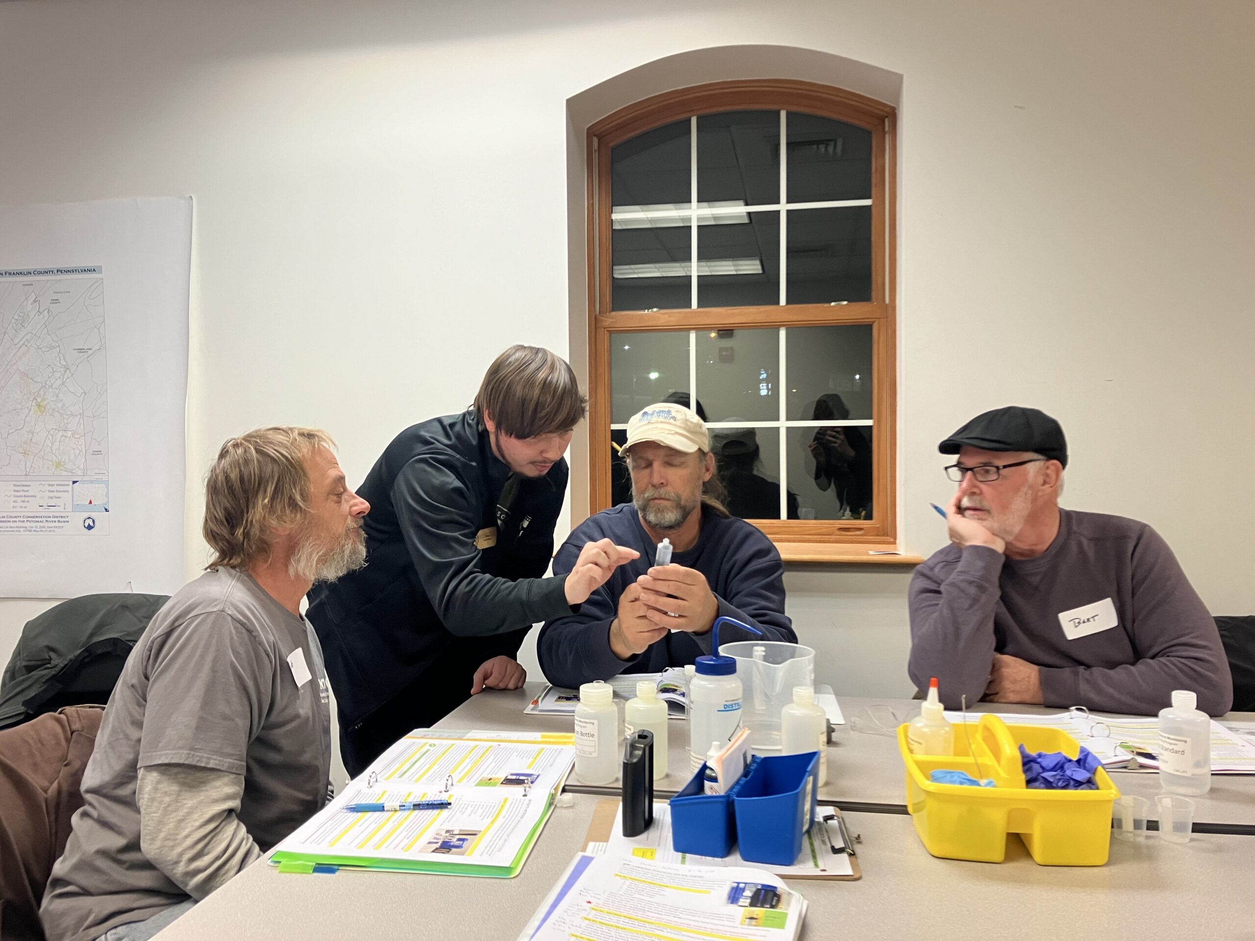 Image shows student watershed coordinator training volunteers in break out group