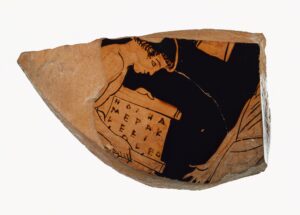 Attic red-figure otter fragment showing a boy reading from a scroll