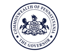 The Pennsylvania State seal for the Governor's Office - Two horses are rearing onto a shield depicting a sailing ship. An eagle is sitting on top of the shield