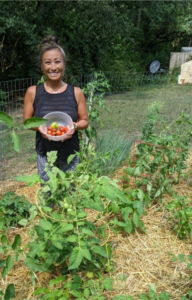 Kristin, one of our home gardeners, holding freshly harvested tomatoes from her garden