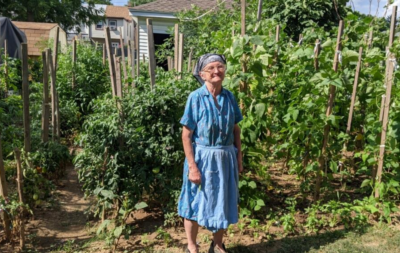 Kaliope, one of our home gardeners, standing in front of her garden