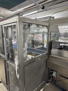 New machine required for new metal containers, utilizes a robotic arm to place covers