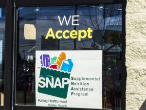 Image of a window with a sign stating, "We Accept SNAP"