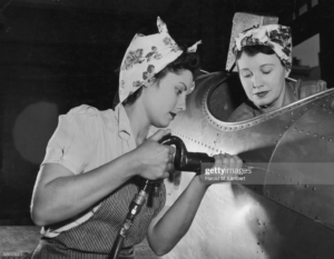 Two women work at an airplane assembly line