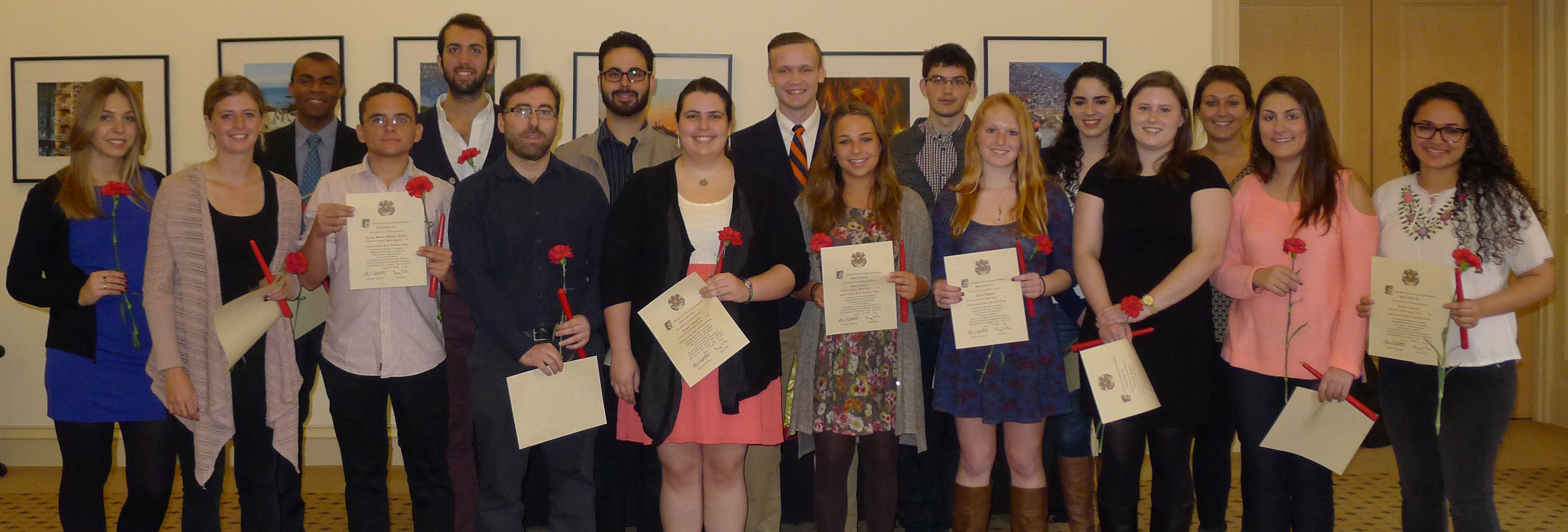 New member of Sigma Delta Pi stand holding their certificates, carnations, red candles and pins after the ceremony.